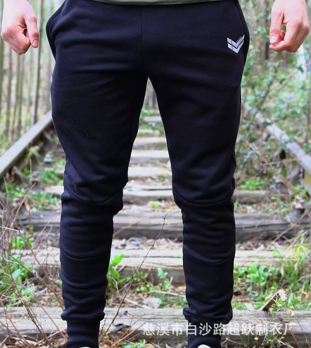Running training pants in black, light gray, or dark gray with 95% cotton fabric and cord closure