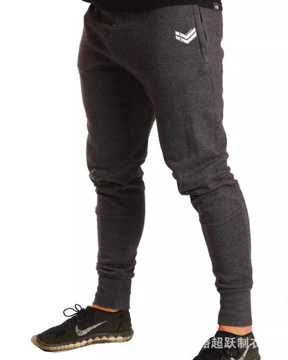 Running training pants in black, light gray, or dark gray with 95% cotton fabric and cord closure