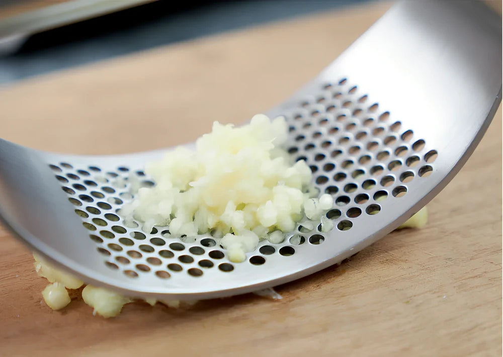 Stainless steel garlic press with uniform mincing holes measuring 10.5cm in length