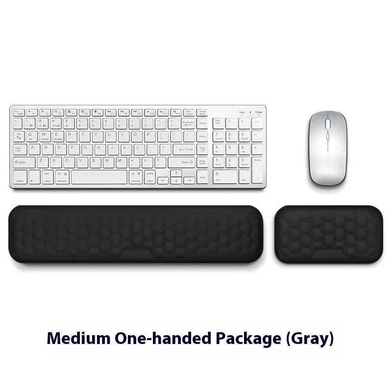 Black and grey memory foam mouse wrist rests with cloth and leather-style covers on a desk.