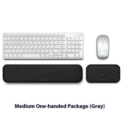Black and grey memory foam mouse wrist rests with cloth and leather-style covers on a desk.
