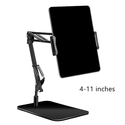 Black universal phone stand with long metal arm and heavy round base on a wooden desk