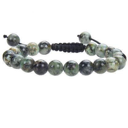 Close-up of a women's flat knot braided healing bracelet hand-woven with colourful gemstones.