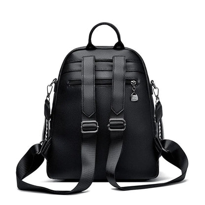 Genuine leather multi-functional commuting backpack with flap pocket, polyester lining, and metal letter patchwork details in black.