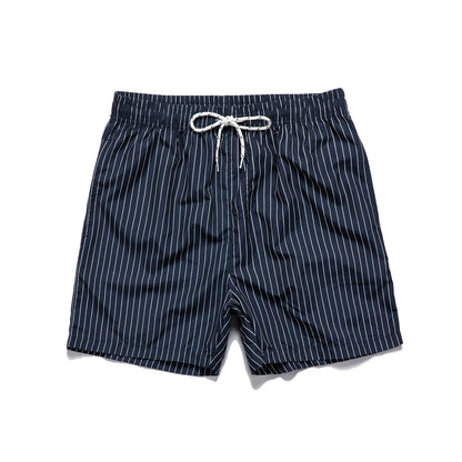 Pair of grey striped polyester shorts with a straight leg cut on a mannequin