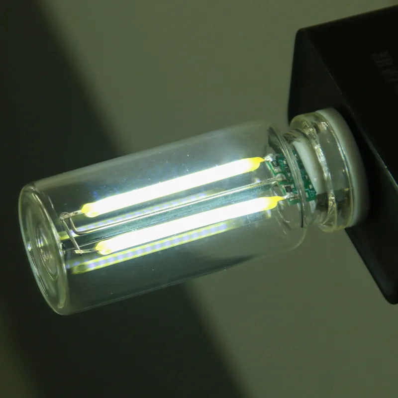 Small transparent glass USB touch night lamp with warm white light on a surface.