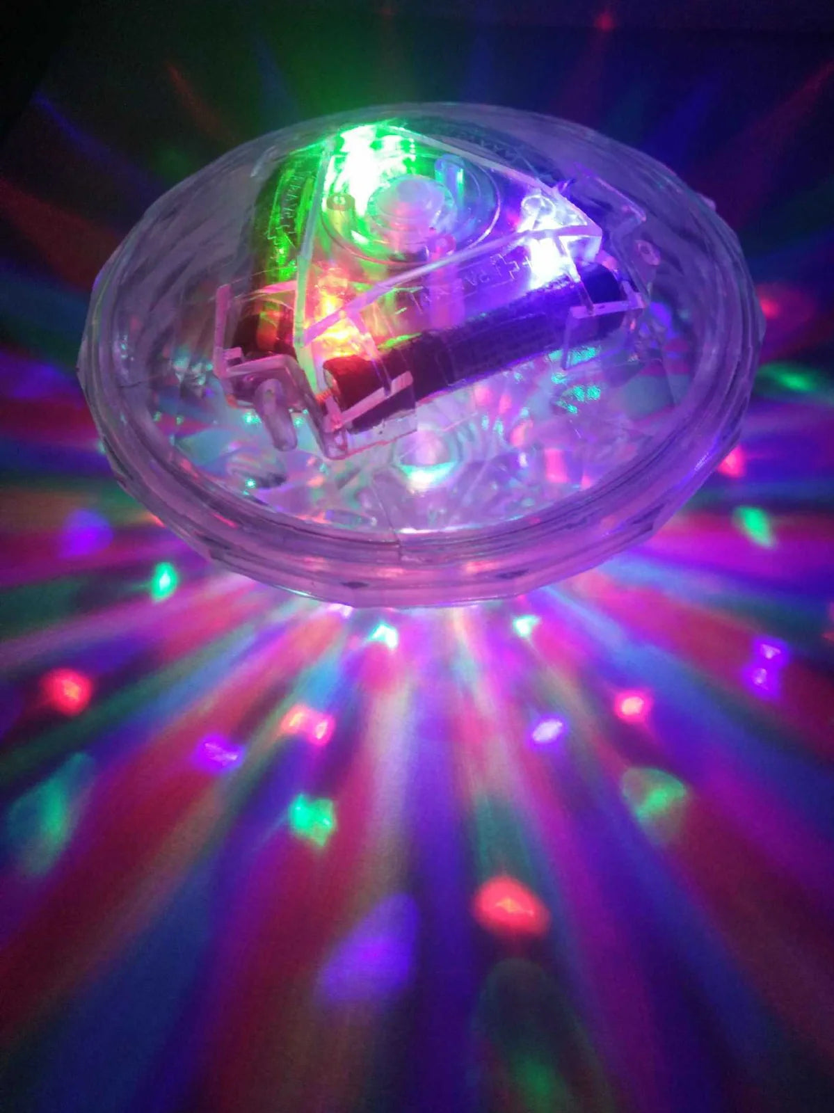 Round water lamp with changing colours submerged in bath, showing blue and purple LED illumination through clear polycarbonate shell