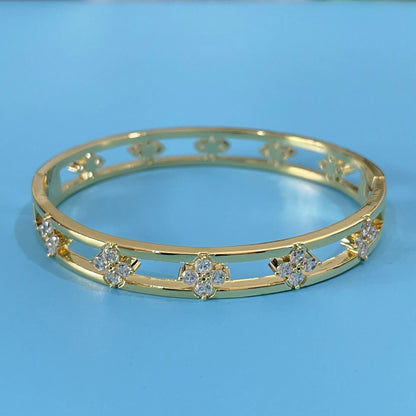 Hollow women's bracelet with four-leaf clover design and inlaid zircon stones in gold or silver finish.