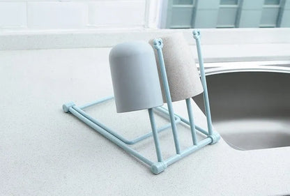 Foldable plastic dishcloth shelf organiser in Nordic style mounted on a kitchen wall