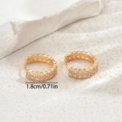 Copper geometry ear studs with round, dot, and ring elements in a unisex design.