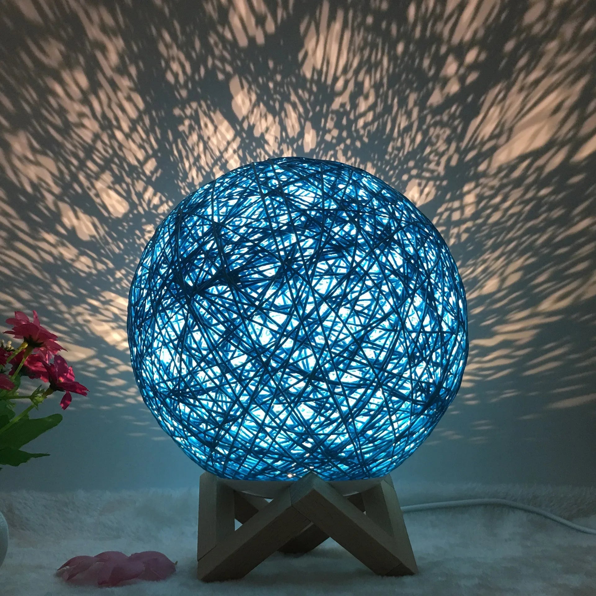 Spherical hand-knitted rattan table lamp with remote control on a wooden desk