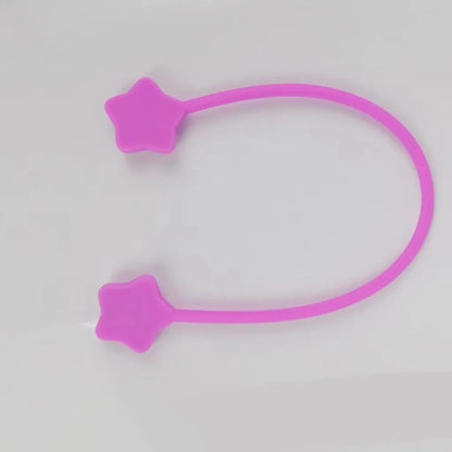 Compact purple silicone cable winder with magnet, shown coiling a white headphone cable.