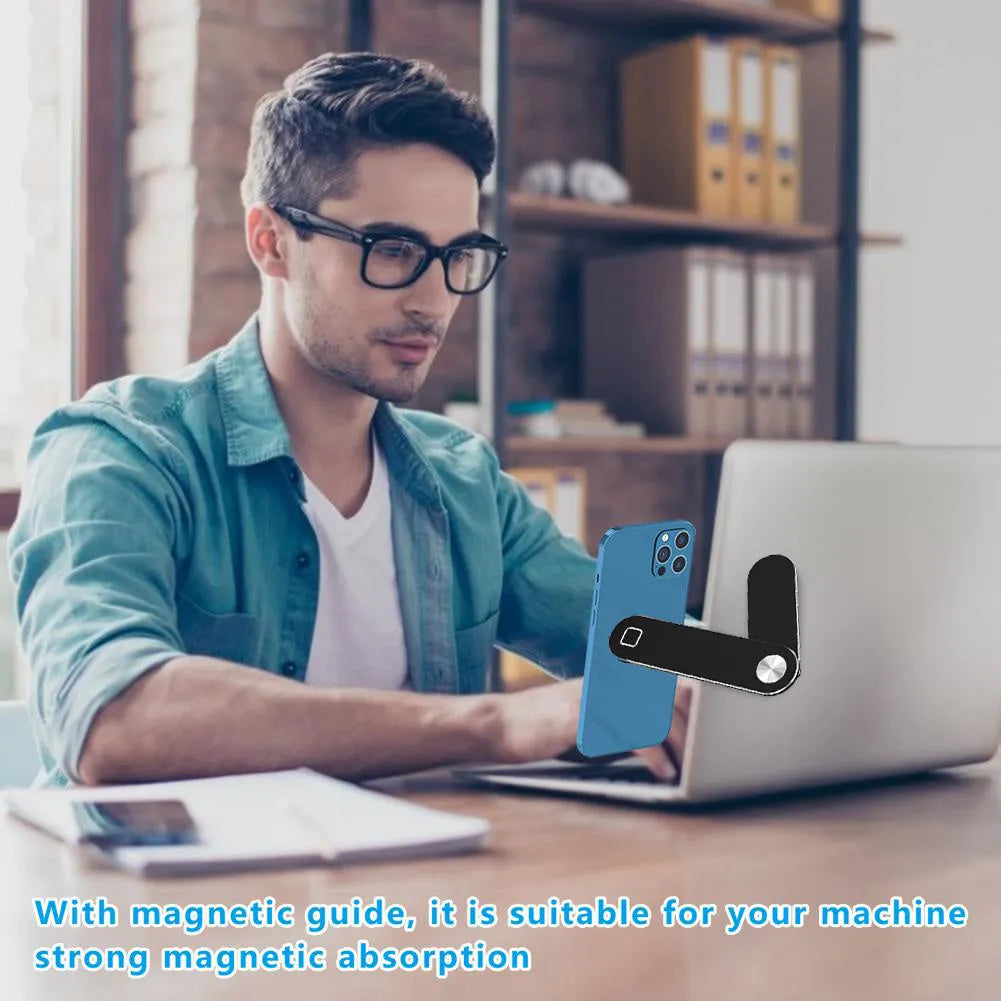 Black laptop phone holder with magnetic clip mounted on silver laptop, showing smartphone in adjustable bracket
