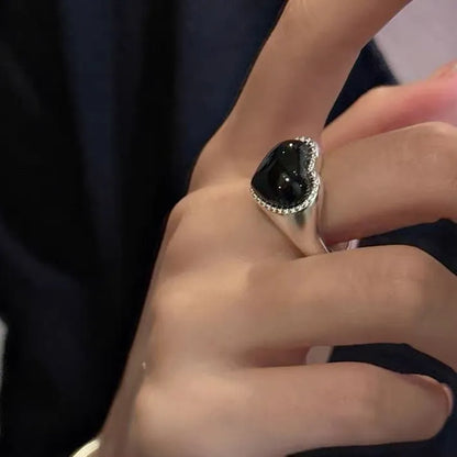 S925 sterling silver ring with a polished black heart-shaped agate stone on an adjustable open band.