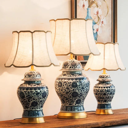 Traditional blue and white Chinese ceramic table lamp with a cloth shade on a bedside table.