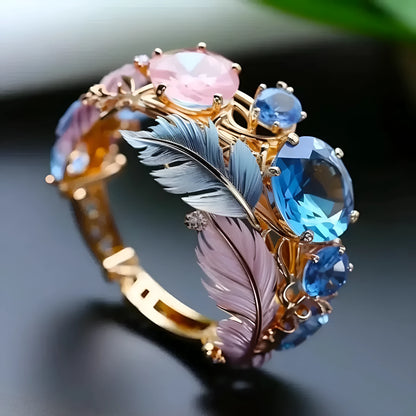 Gold colour brass feather ring with embossed geometric design and zircon inlays showing colourful pattern detail