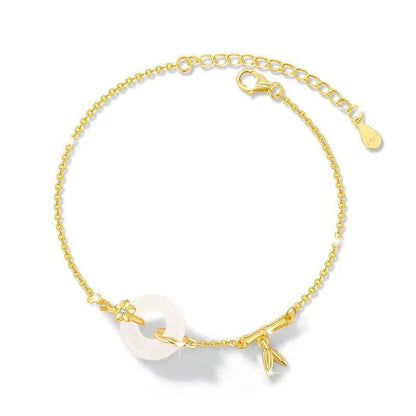 Gold-colour women's bracelet with peace symbol buckle and white chalcedony stone on silver band.