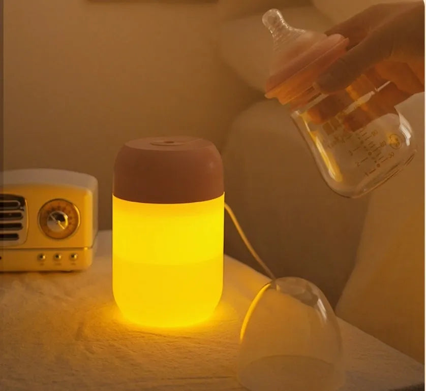 White cylindrical humidifier with USB cable on a desk, showing compact 15cm height and aromatherapy function for essential oils.