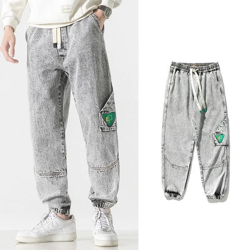 Men's loose-fit tapered cotton trousers in black showing mid-waist design and tapered leg opening