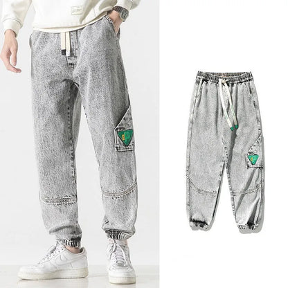 Men's loose-fit tapered cotton trousers in black showing mid-waist design and tapered leg opening