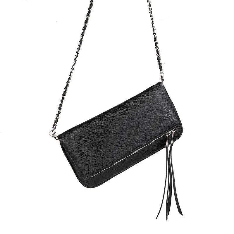 Soft black PU leather women's clutch bag with a gold chain strap, shown held and worn cross-body.