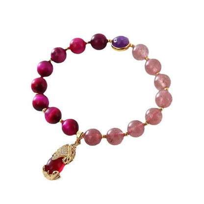 Simple women's bracelet with a red strawberry crystal charm on a black elastic rope.