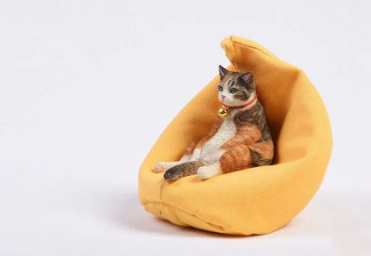 Lazy cat ornament on miniature sofa for car dashboard decoration, 7.5cm high with fabric art detailing