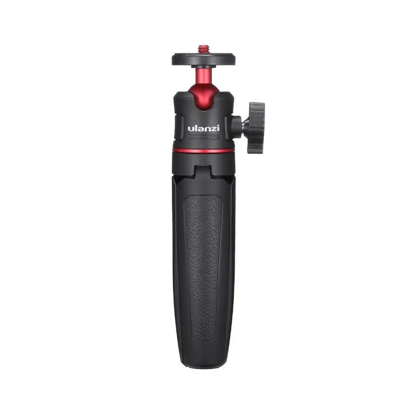 Compact black red and white phone tripod selfie stick stand extended next to a mobile phone.