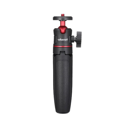 Compact black red and white phone tripod selfie stick stand extended next to a mobile phone.