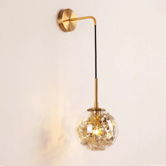 Glass wall lamp with golden flower finish and 15cm diameter, mounted beside bed with LED illumination