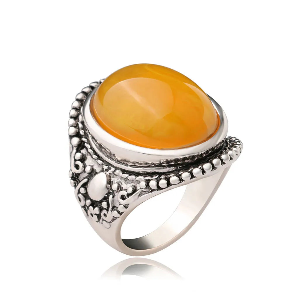 Geometric antique silver amber alloy ring with fluorescent beeswax plating on a model's finger.