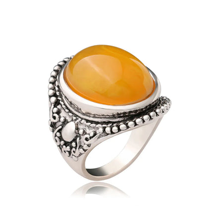 Geometric antique silver amber alloy ring with fluorescent beeswax plating on a model's finger.