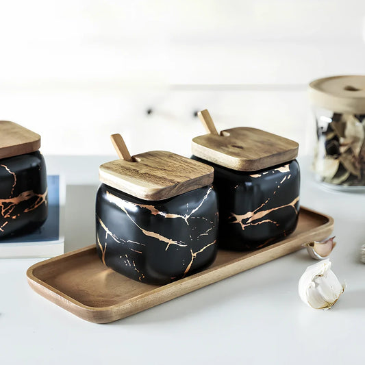 Three-piece Nordic Gold Marble Jar Set in white ceramic with wooden tray and bamboo spoons on kitchen counter