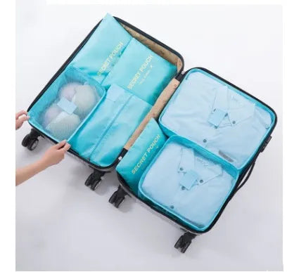 Set of six coloured nylon packing cubes and flat pouches for travel organisation.