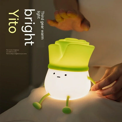 Green onion-shaped night light with warm white glow on desktop, showing 125mm width and flower design