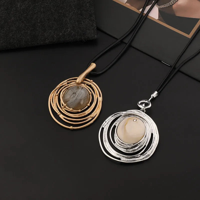 Gold geometric plaid pendant necklace on a textured snakeskin-style rope chain, laid out to show length.
