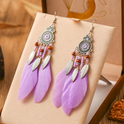 Bohemian feather leaf pattern alloy earrings in round drop shape on a colour selection background.