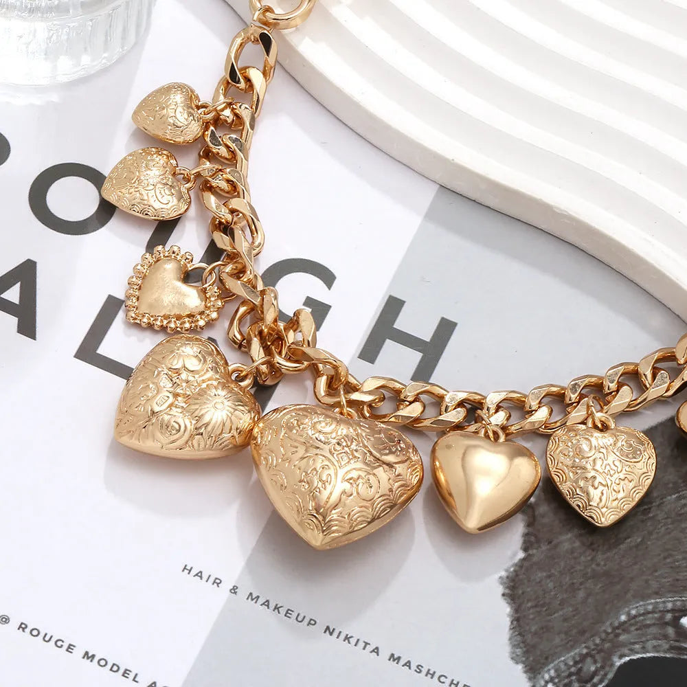 Gold carved heart pendant necklace on adjustable chain, showing exaggerated shape and textured details
