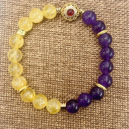 Handmade women's crystal bracelet in yellow and purple colours on a wrist.