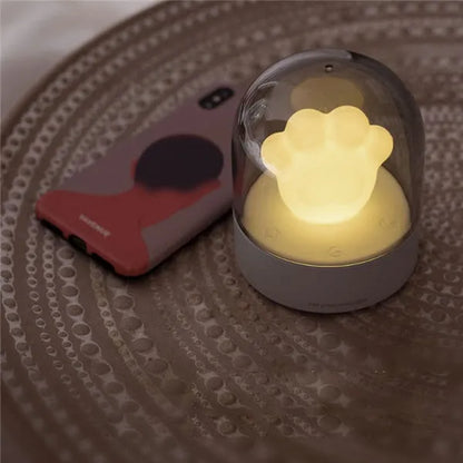 Grey cat paw shaped night light with USB port, sitting on a surface with soft glow.