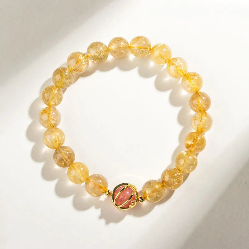 Citrine and gold rutilated quartz stretch bracelet with diamond-cut beads on an elastic band.