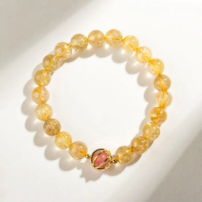Citrine and gold rutilated quartz stretch bracelet with diamond-cut beads on an elastic band.