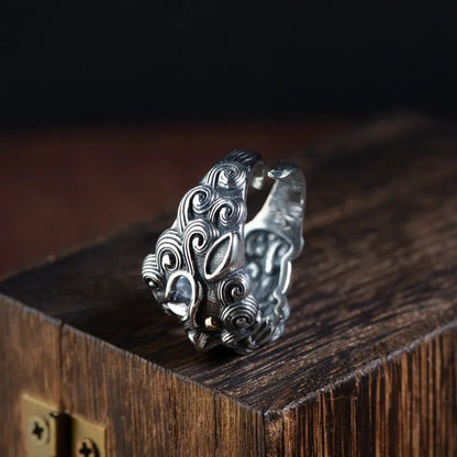 Silver open-style ring with a detailed raised jibeast animal pattern on a model's finger.