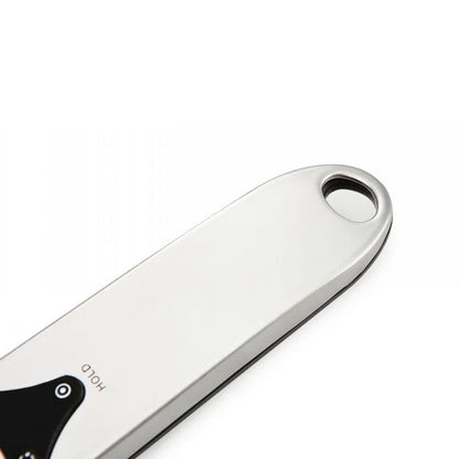 Smart digital measuring spoon with electronic display showing weight, alongside two AAA batteries.