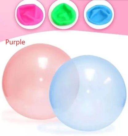 Large pink, yellow, green, and blue inflatable bouncy balls in various sizes for children's play.