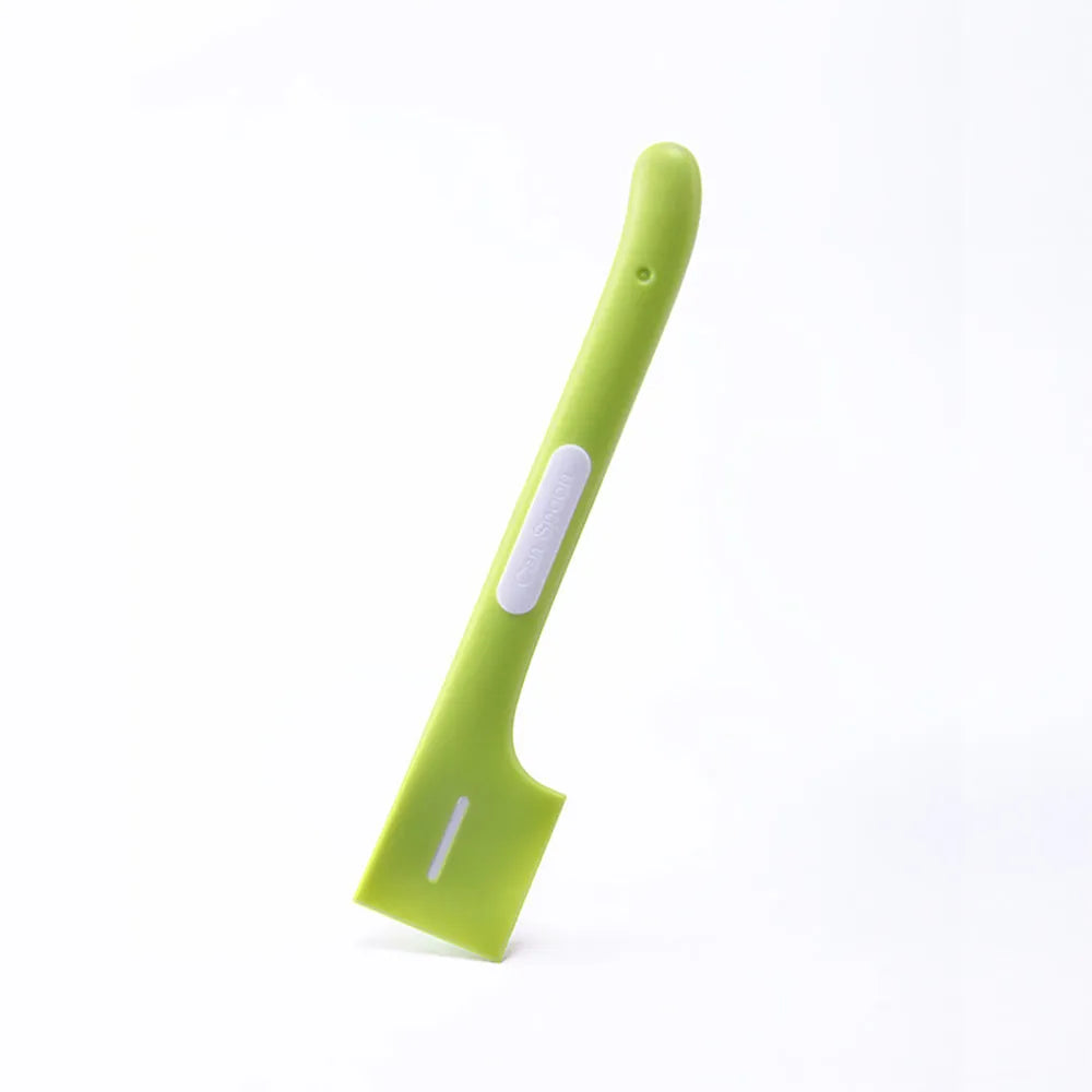 Green long-handled plastic spoon for scooping pet food from a can.