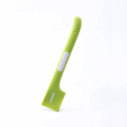 Green long-handled plastic spoon for scooping pet food from a can.