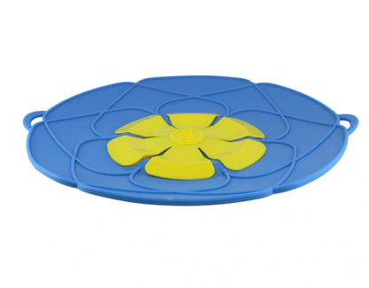 Green silicone spill stopper pan lid on cooking pot showing flexible edges and steam vent