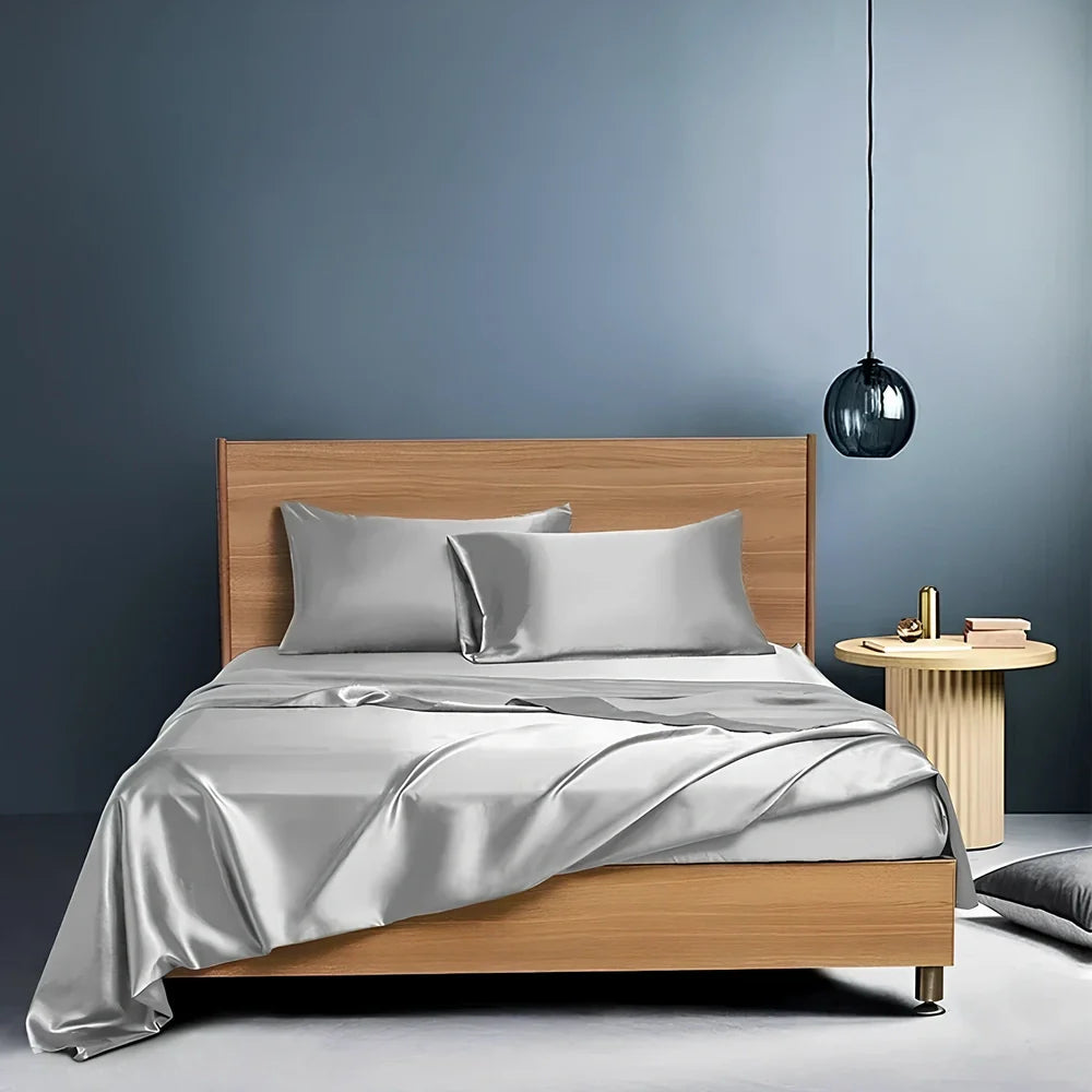 Navy blue floral pattern silk bedding set with quilt cover, fitted sheet, and two pillowcases on bed