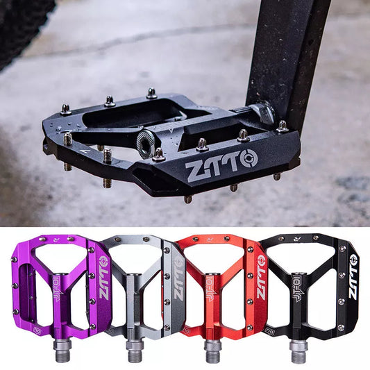 Aluminum alloy bicycle pedal with chrome molybdenum steel shaft in black, red, silver, and purple